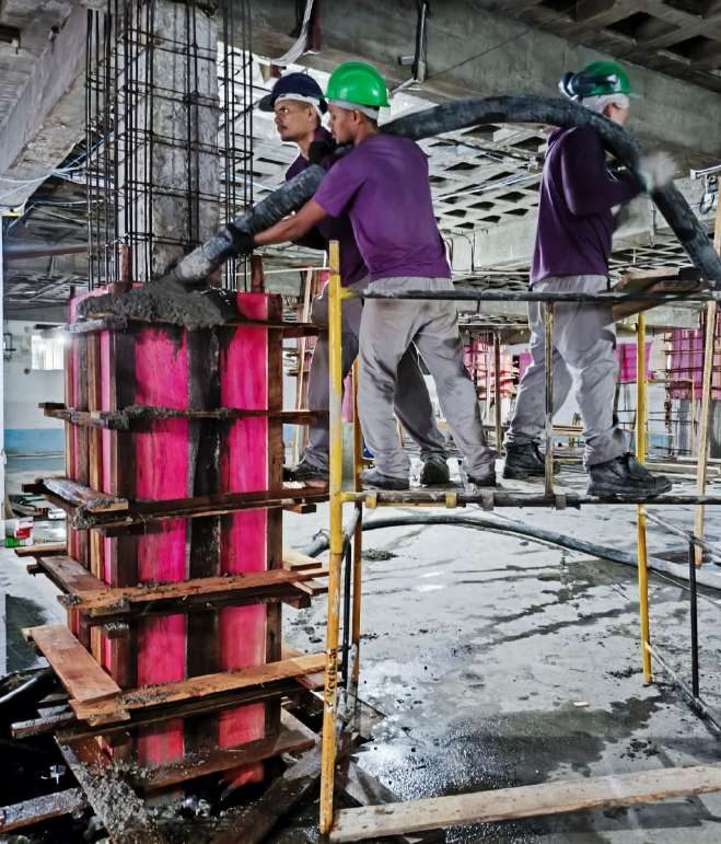 Equipe da UF Construções concretando um pilar com fôrma de madeira em obra